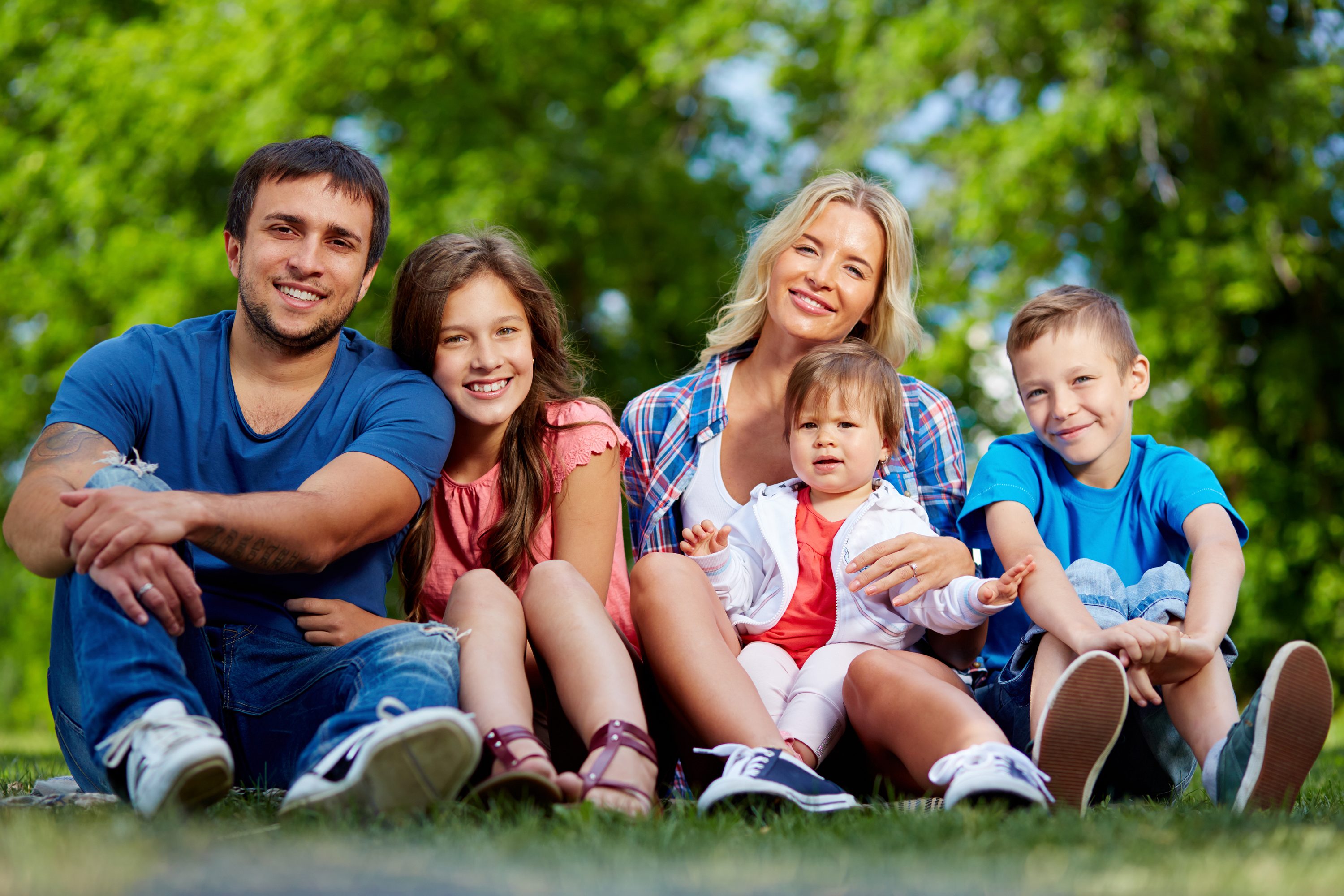 Photo of happy family looking at camera outdoors